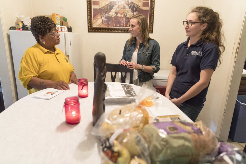Meals recipient Montine Brightwell, left to right, talks with senior psychology major Alaina Buschman of Roswell, and campus kitchen assistant coordinator and AmeriCorps VISTA Kaeli Evans as they deliver meals to her home in Athens. (Andrew Davis Tucker/UGA)
