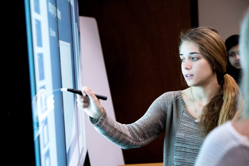Isabel Carvalo, a fourth-year student in genetics, presents data on iWall technology located in the science library. (Dorothy Kozlowski/UGA)
