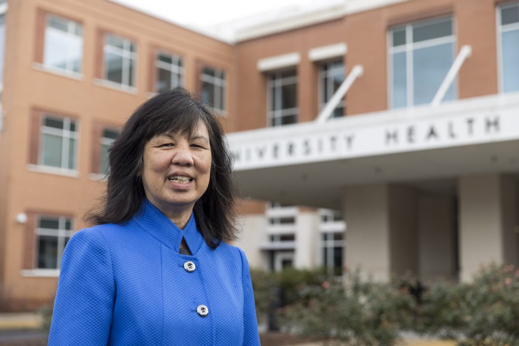 Jean Chin smiles in front of the University Health Center