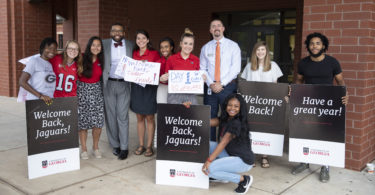 UGA students pose with Alton Standifer, fourth from, left, assistant to the president at UGA, and Cedar Shoals Principal Derrick Maxwell after welcoming students back on the first day of Clarke County Schools on Aug. 5.
