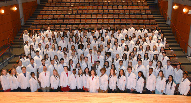 Photo of pharmacy students in white coats.