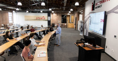 A professor teaches students in the Innovation Hub.