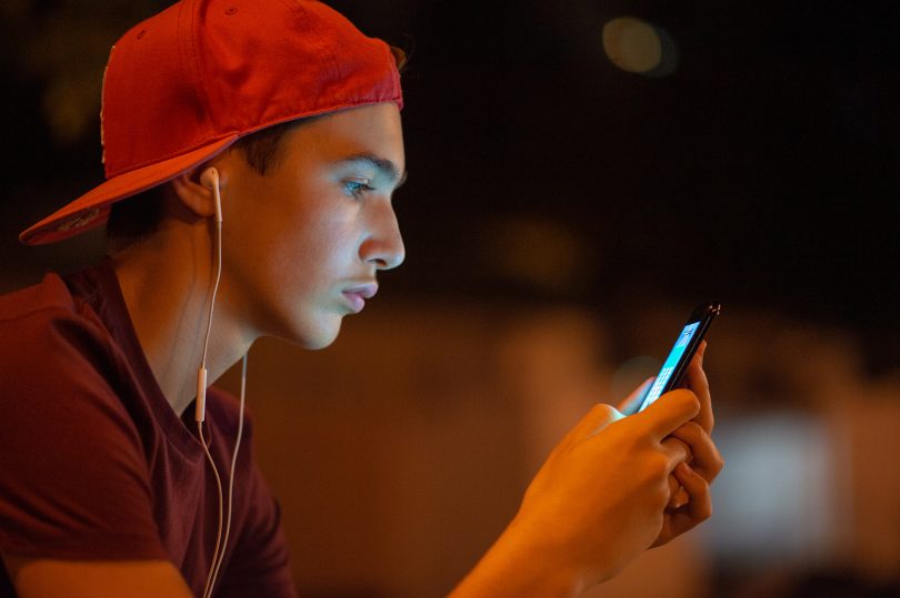 Close-up portrait of a young man with smartphone
