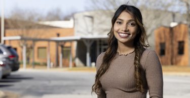 Christina Kurian in front of elementary school