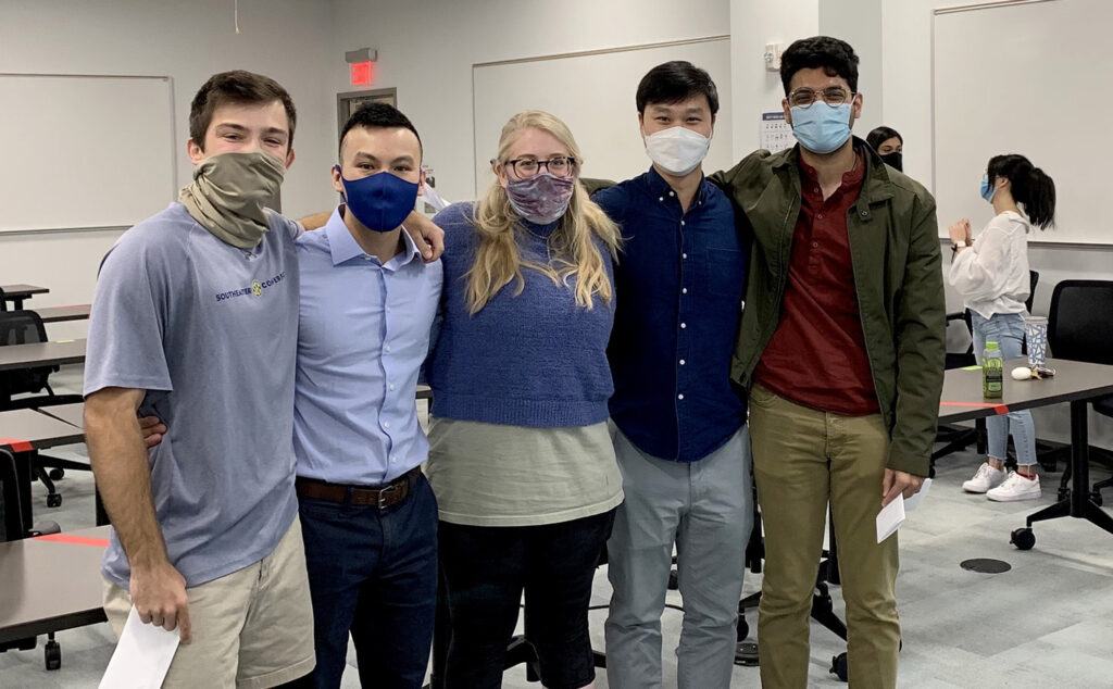 A group of five people wearing face coverings for the pandemic