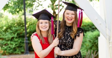 Amelia and Megan Holley wear graduation mortarboards and ring the UGA Chapel Bell.