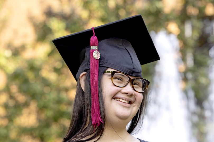Marina Martinez wears a graduation mortarboard smiles.