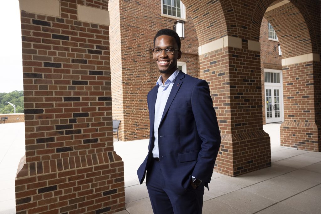 Portrait of Kevin Nwogu wearing a suit standing in the Business Learning Community,