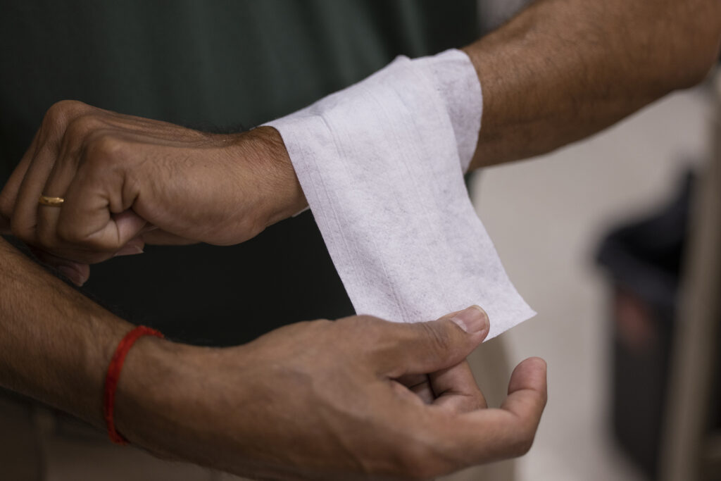 A man demonstrates how the nonwoven material can wrap around a wrist.