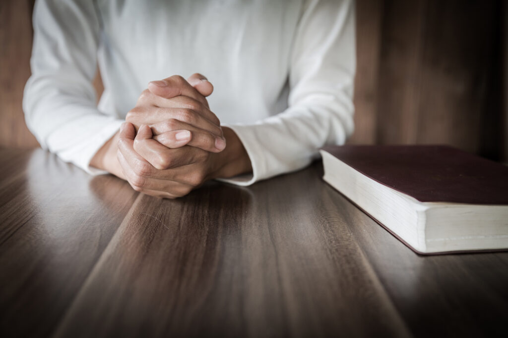 A photograph of a minister's hands and a bible.