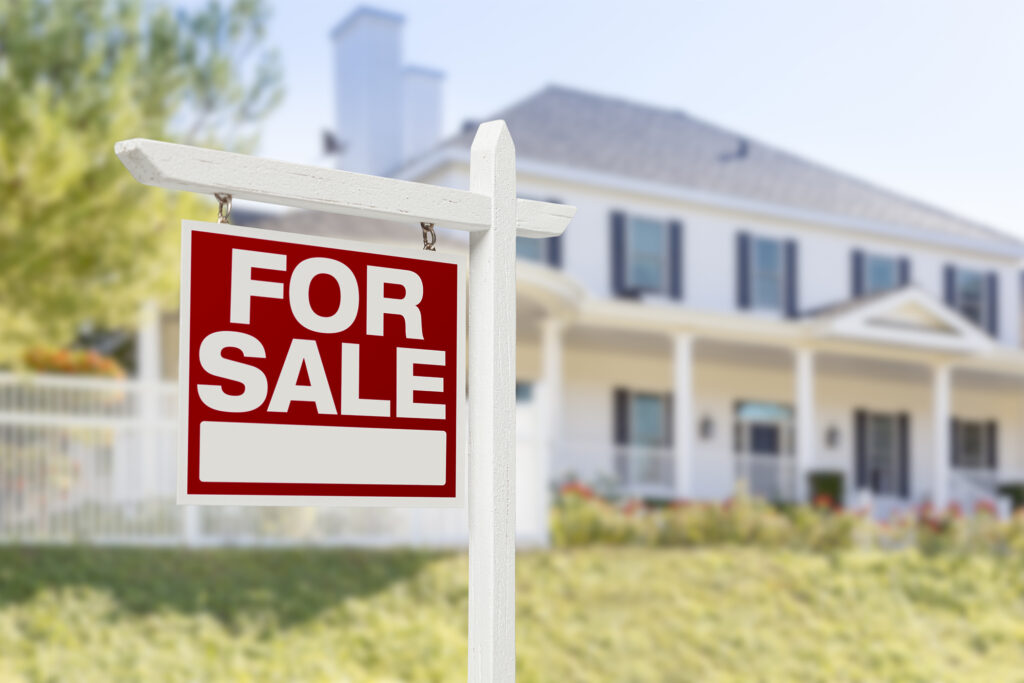 House with for sale sign in front