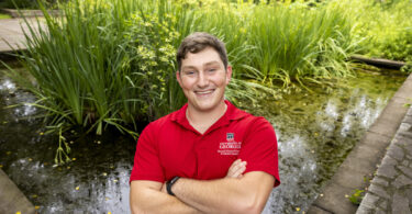 Seamus OBrien poses in front of a turtle pond.