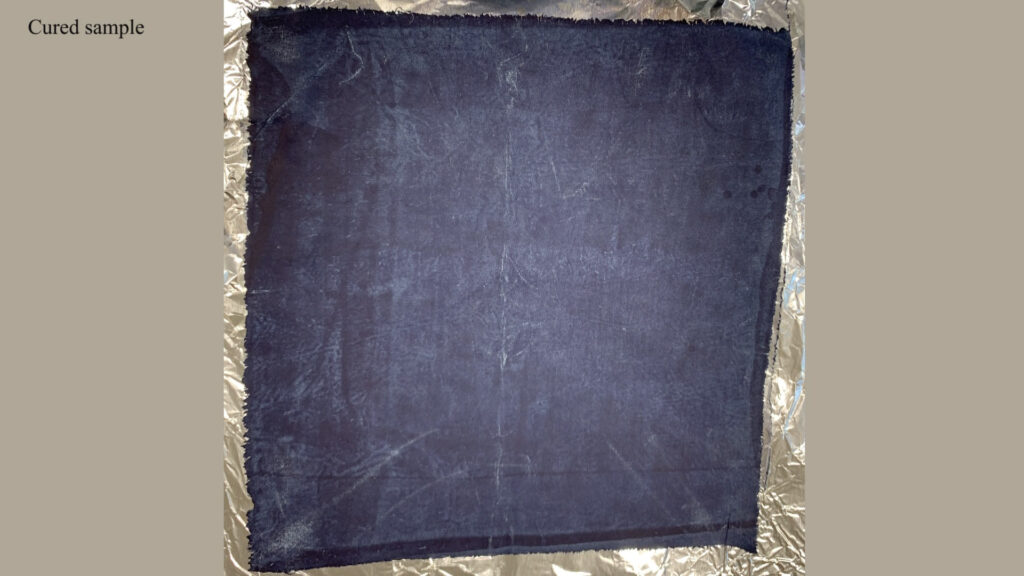 A piece of indigo-dyed fabric is shown after it has been distressed