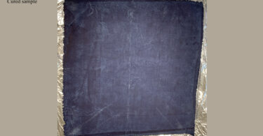 A piece of indigo-dyed fabric is shown after it has been distressed