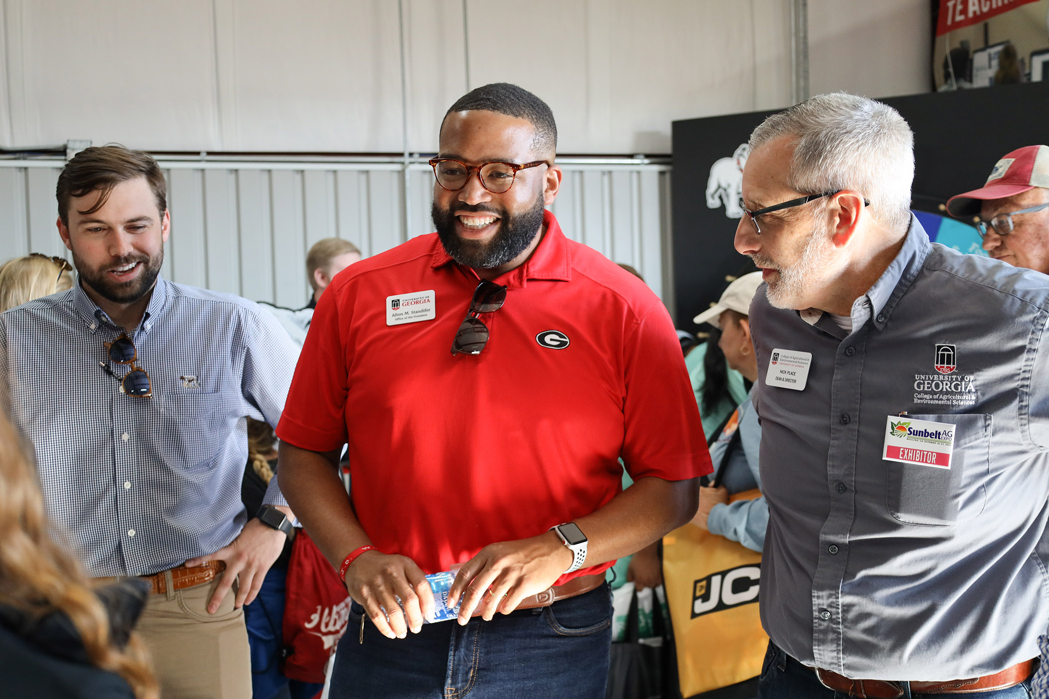Blake Raulerson, Alton Standifer and Nick Place talk with CAES Ambassadors at the Sunbelt Ag Expo in Moultrie, Georgia.
