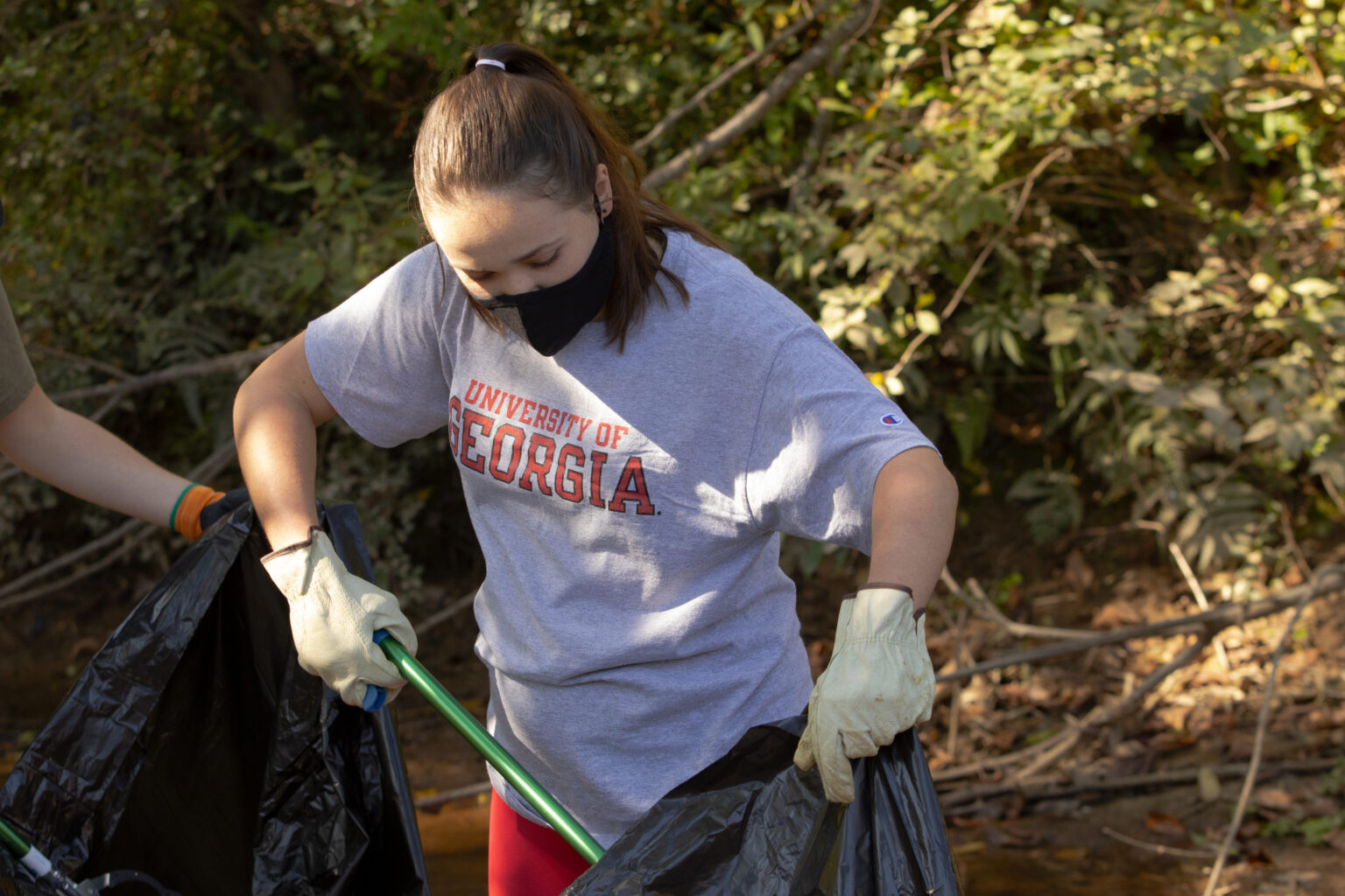 Students help install trash trap to clean up creek