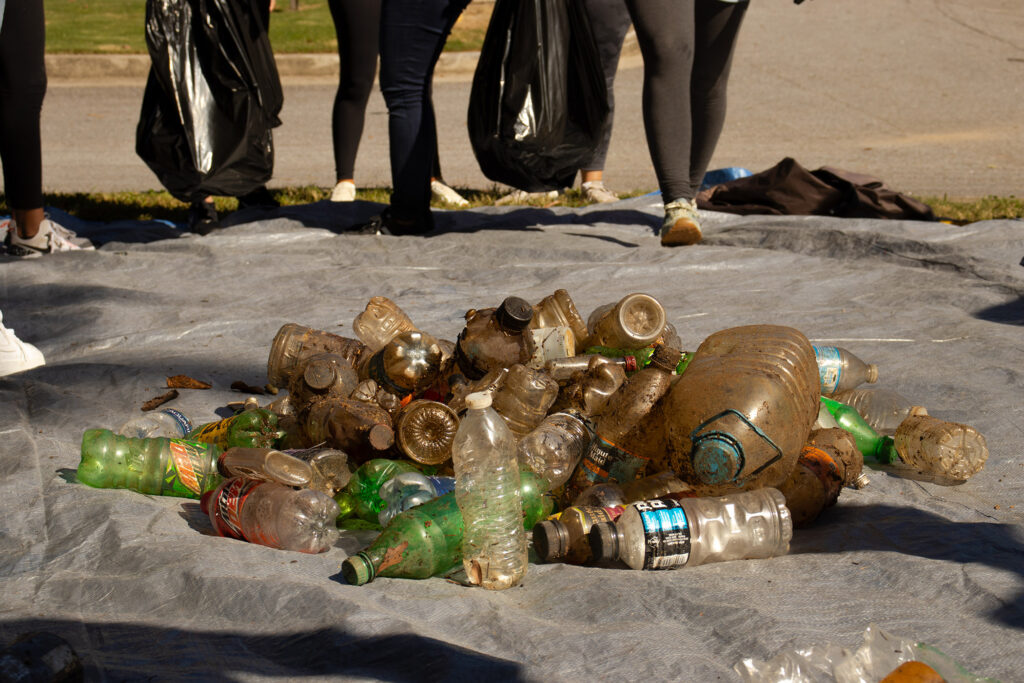 A pile of plastic bottles and trash on a tarp.