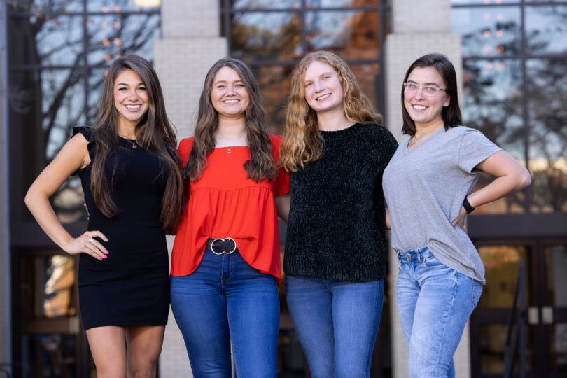 Four college freshman stand together for environmental portrait