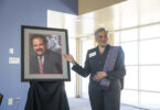 Marilyn Holmes stands beside portrait of her late husband, Hamilton Holmes Sr.