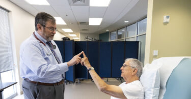An Alzheimer's patient at UGA's Care center works on small motor skills with a doctor.
