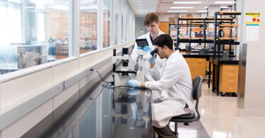 two students in a lab and white lab coats