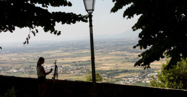 student painting overlooking a hillside in Cortona, Italy