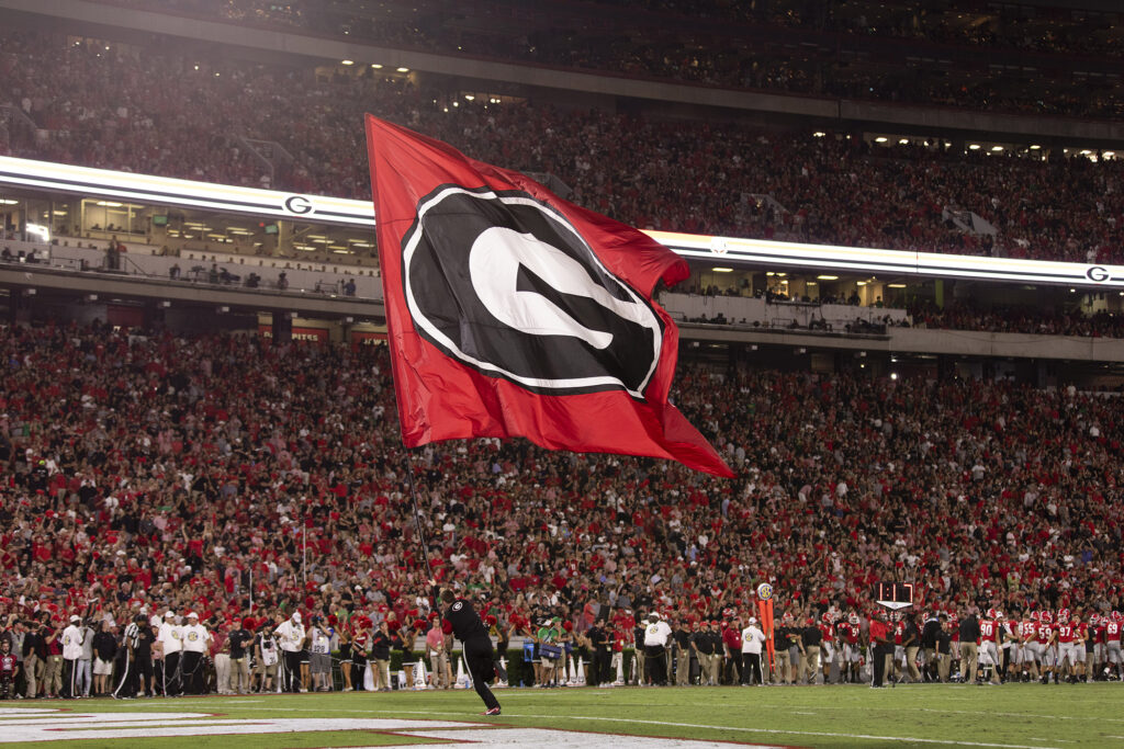 A cheerleader runs through the end zone with a PowerG flag after a touchdown during the UGA vs. Notre Dame football game in Sanford Stadium.