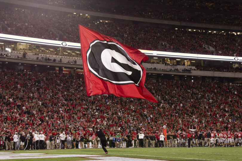 A cheerleader runs through the end zone with a PowerG flag after a touchdown during the UGA vs. Notre Dame football game in Sanford Stadium.