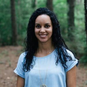 Environmental portrait of Analisa Arroyo wearing a light blue shirt in the woods.