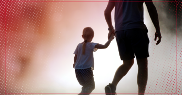 A silhouetted man holds the hand of a young boy.