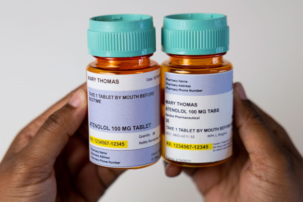 Two prescription pill bottles are shown side by side, highlighting the differences between new patient-friendly labels and traditional ones.