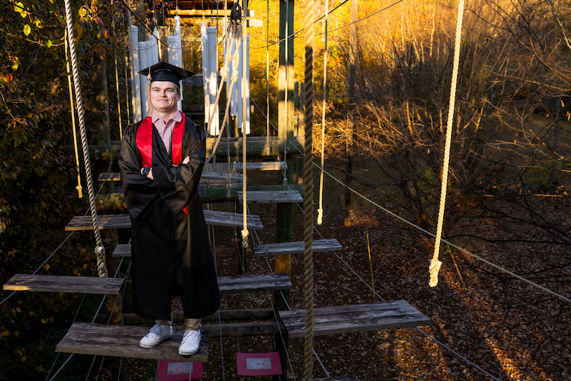 Commencement student speaker Kyle Huemme poses on the Challenge Course at Lake Herrick.