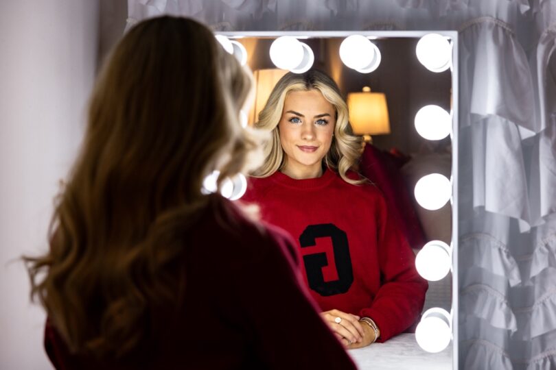 Jillian Rhae Maxwell portrait in front of lighted mirror