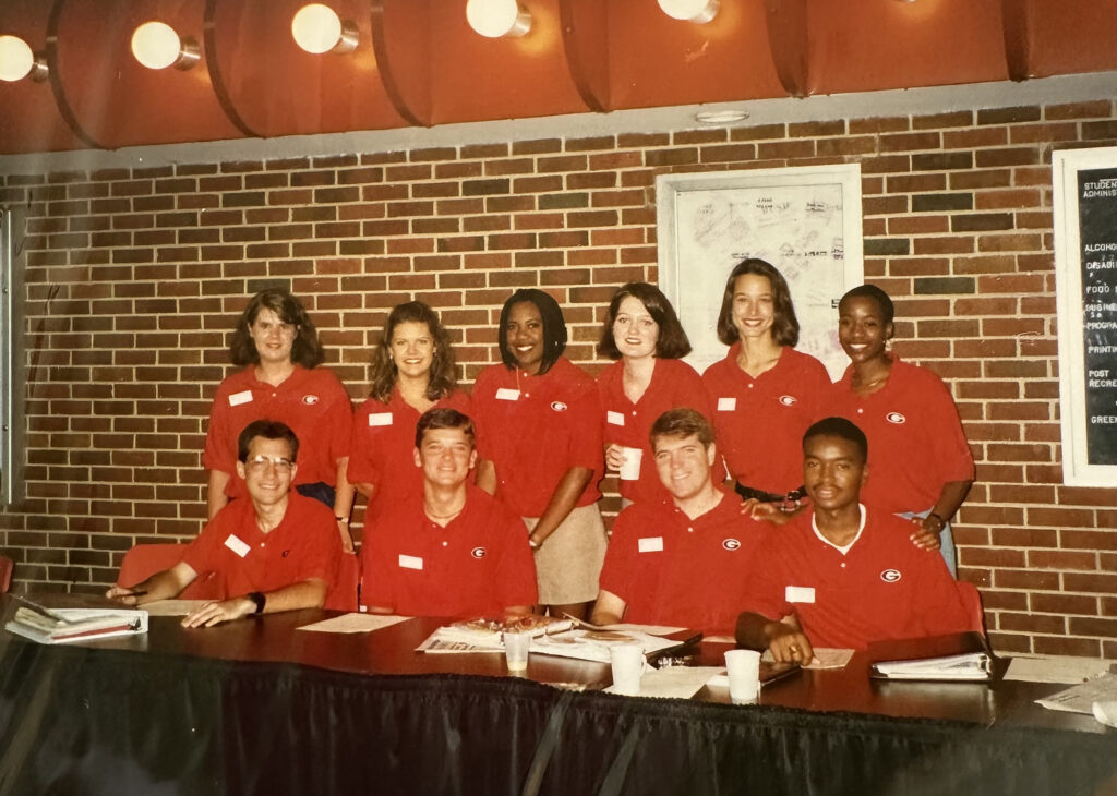 An older photo of a group of UGA orientation leaders wearing red shirts and white nametags.