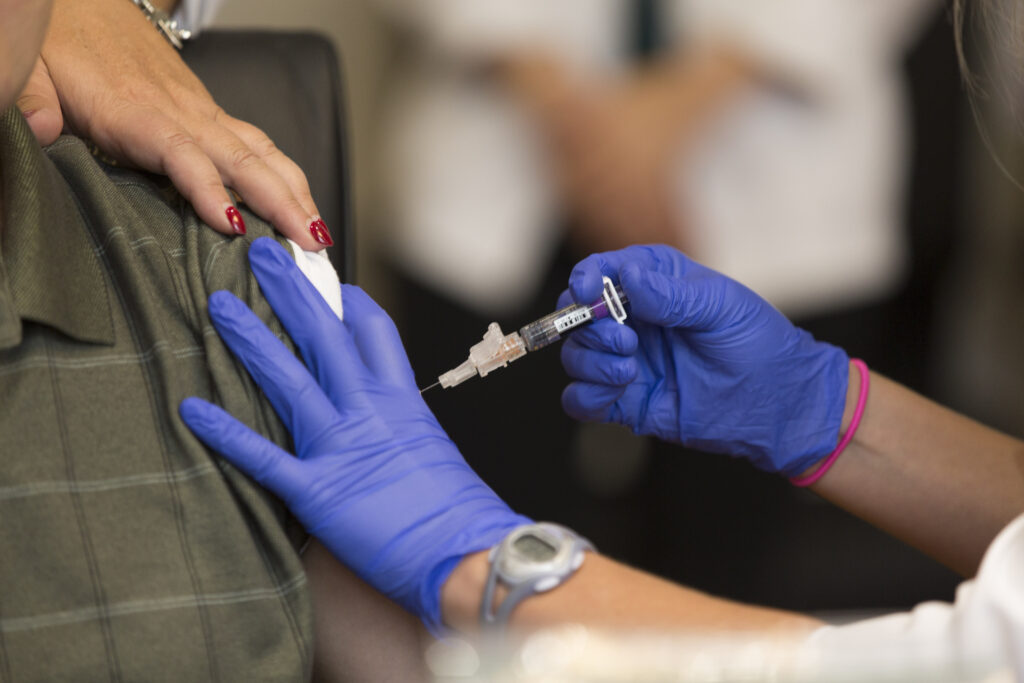 close up of gloved hand giving shot into arm