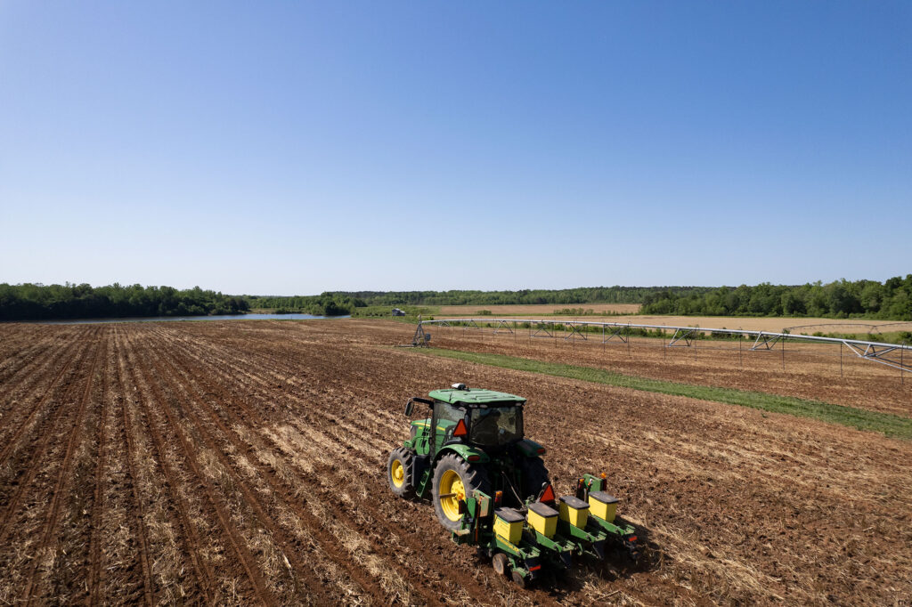 A tractor operator plants corn on a rural farm in Georgia.