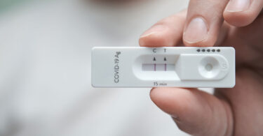 A person holds a positive COVID-19 test.