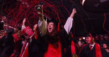 Streamers fall over the crowd during fall 2024 undergraduate commencement at Stegeman Coliseum.