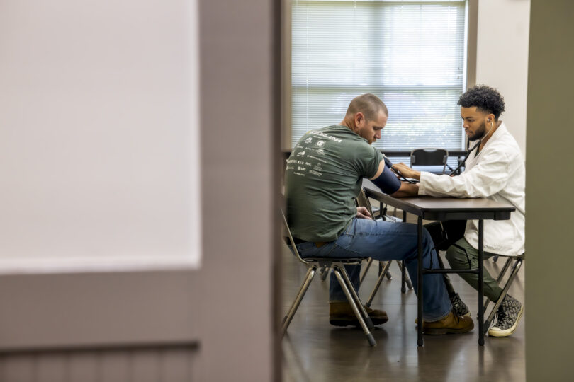 Medical student Khase Willis performs a medical exam on a patient at the Potter’s House in Athens, GA during one of the free clinics provided by the Medical Partnership.