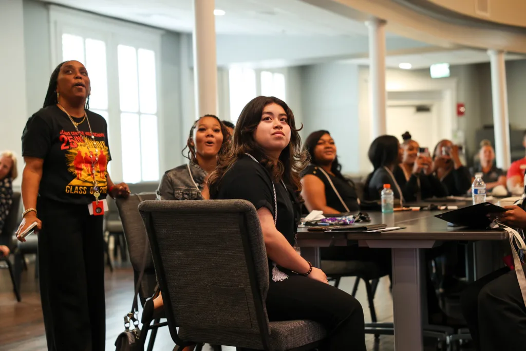 Attendees listening during a presentation in a bright, modern room.
