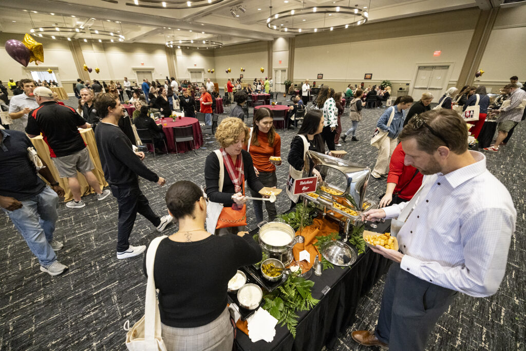 A photo from above of people mingling around food stations.
