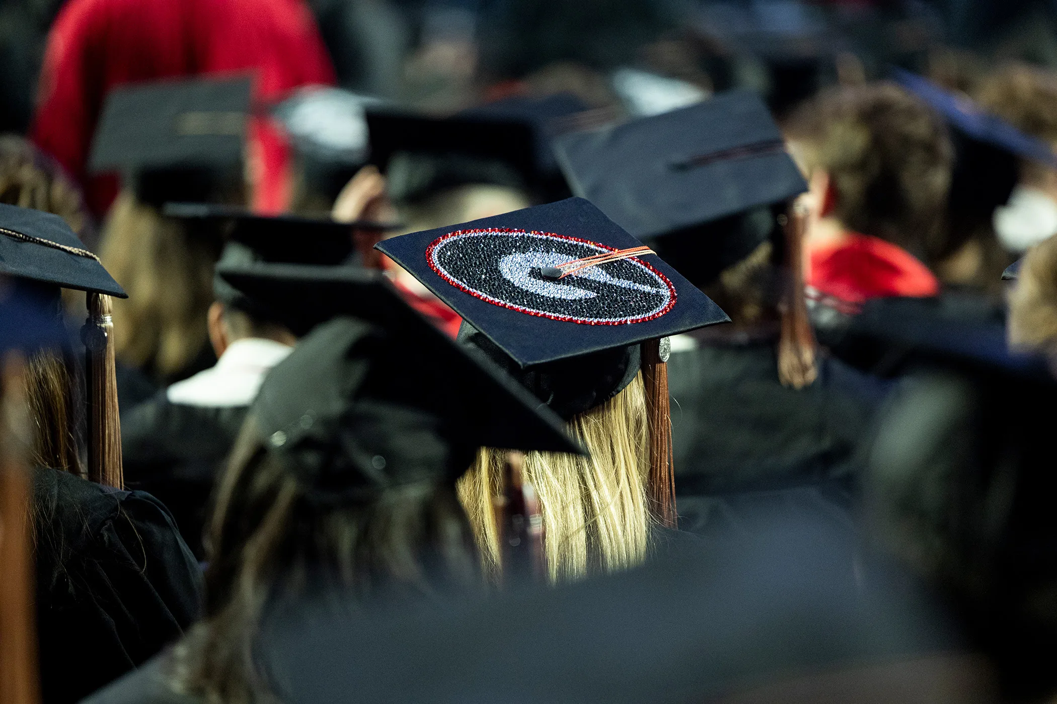 Detail of a decorated mortarboard worn by a student during a fall Commencement ceremony in Stegeman Coliseum.