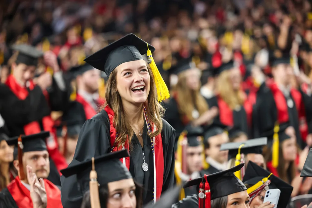 A graduate smiles during the conferring of degrees at fall undergraduate Commencement.