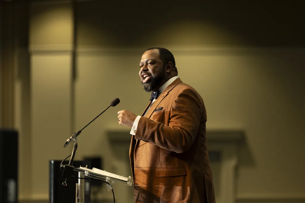 A man delivers a keynote address from a podium.