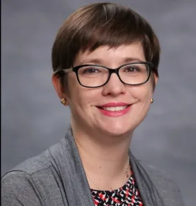 Headshot of a woman against a gray background