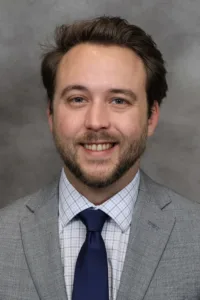 Headshot of a man against a gray background