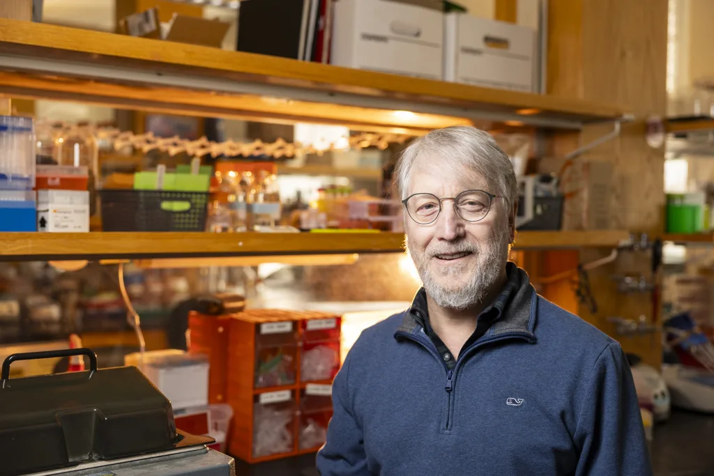 A university faculty member poses for a photo in a lab