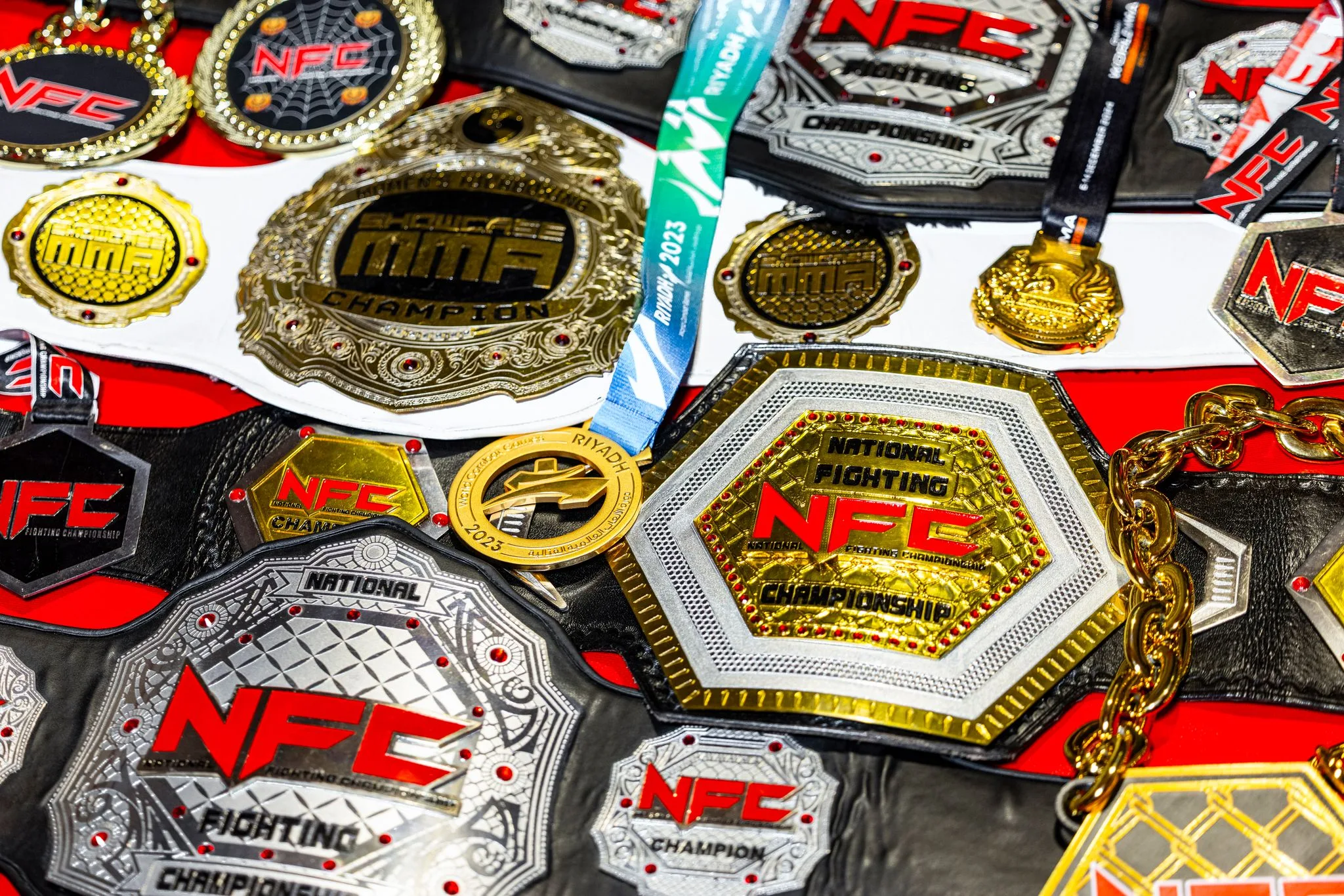 A close-up of a variety of MMA championship belts and medals. 