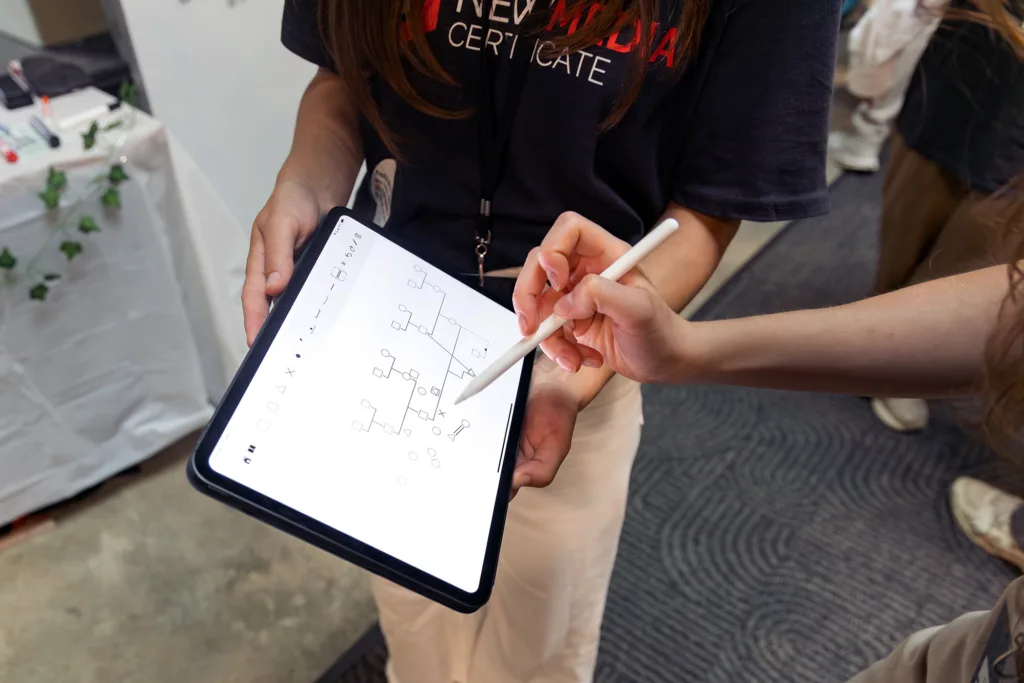 An attendee uses a stylus to interact with the GKnow iPad app demo.