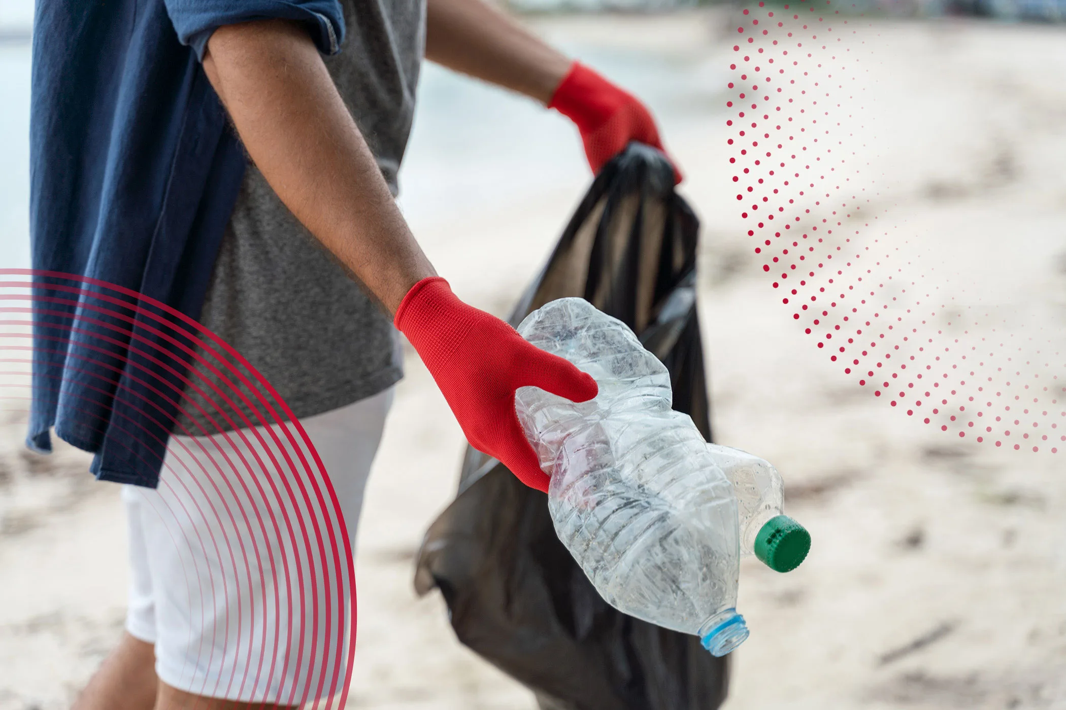 A photo of someone in red gloves picking up trash on a beach.